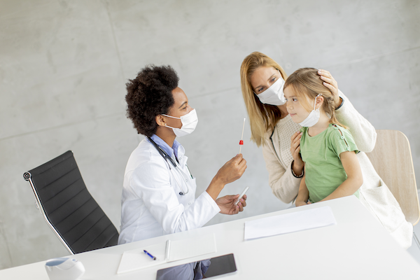 doctor giving a young girl patient, a lollipop